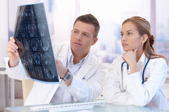 Two doctors studying x-ray image consulting