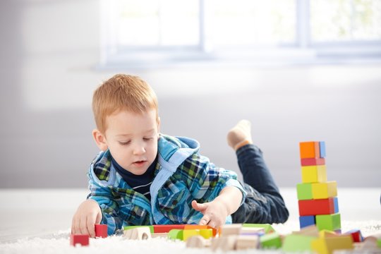 3 year old playing with cubes on floor
