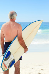 Naklejka na ściany i meble Retired man with his surfboard