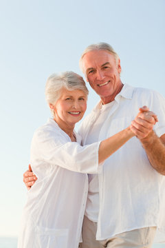 Senior Couple Dancing On The Beach