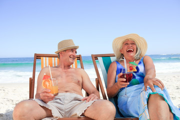Mature couple sitting on deck chairs