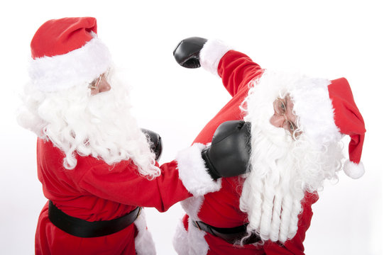 Two santa claus on white background are boxing