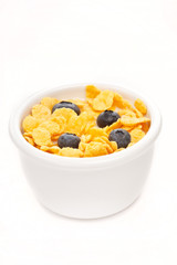 bowl of cornflakes with milk and blueberries