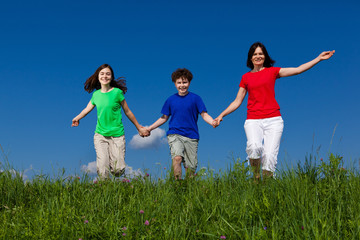 Active family - mother and kids running outdoor