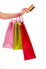 Female hand holding colorful shopping bags and a credit card