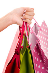 Woman hand carrying a bunch of shopping bags, isolated on white.