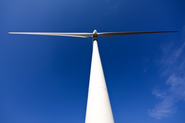 white wind turbine generating electricity on blue sky