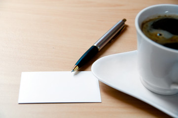 Blank card in a workplace and a cup of coffe