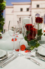 Gedeckte Festtafel mit Rosendekoration.