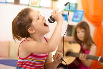Young girl singing with microphone at home