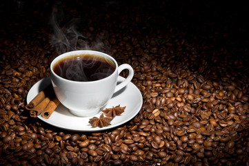 Obraz na płótnie Canvas White cup of hot coffee on coffee beans