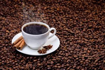 Fototapeta premium White cup of hot coffee on coffee beans