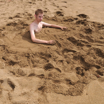 Young Man Burried In The Sand