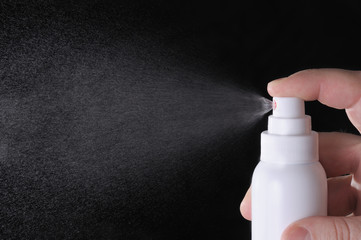 closeup view of human hand spraying liquid in the empty space