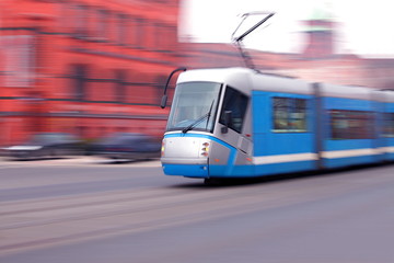 Modern  blue tram rider fast on rails