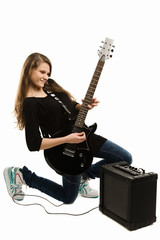 Happy teenager girl playing guitar