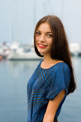 Girl on the waterfront, against a background of yachts