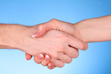 handshake between man and woman on blue background