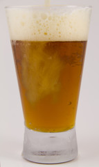 Frosty glass of cold beer being poured