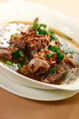 A bowl of beef rib soup sprinkled with spring onion