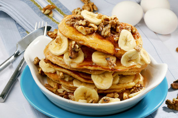 stack of tasty golden pancakes with slices of banana