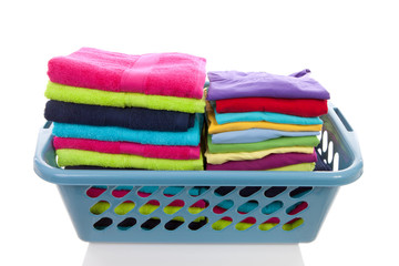 basket filled with colorful folded laundry over white