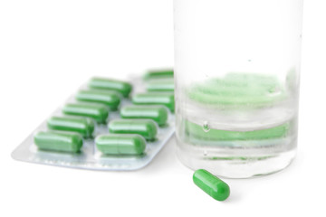 Green pills and glass