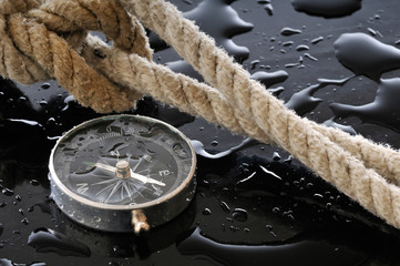 Wet compass and knot on black background - 30330160