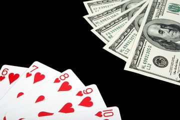 Playing cards and money on black background