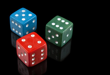 Red, green and blue dices on black background