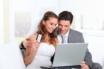Bride and groom doing shopping on inernet at home