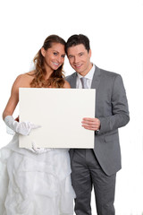 Bride and groom holding whiteboard