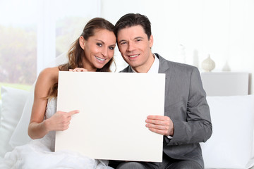 Bride and groom holding whiteboard