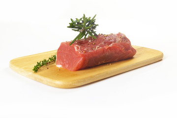 rohes Schweinefilet mit Kräutern auf Holzbrett / raw pork with h