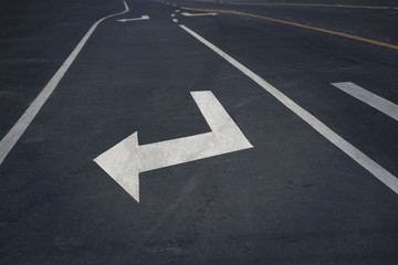 Arrow sign on asphalt