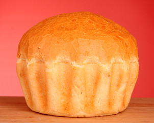 Fresh wheat bread on red background
