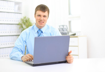 Portrait of busy manager typing on the laptop in the office