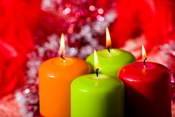 Christmas candles against a tinsel and red sphere