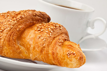 Breakfast: coffee and croissant with sesame seeds