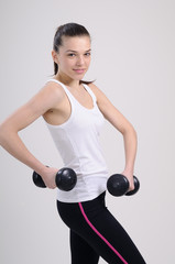 Fototapeta premium girl practicing bodybuilding with dumbbell