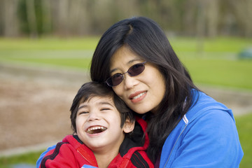 Asian mother holding her little son at the park