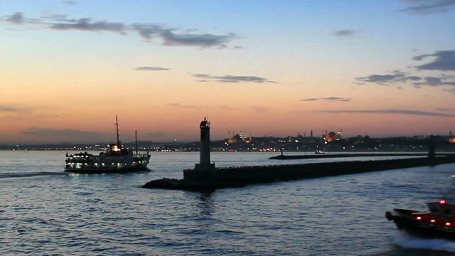 Ferry and tug boat leaves from Kadikoy harbor in sundown