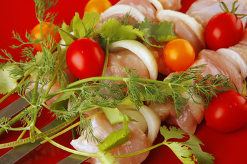 raw chicken kebabs on red