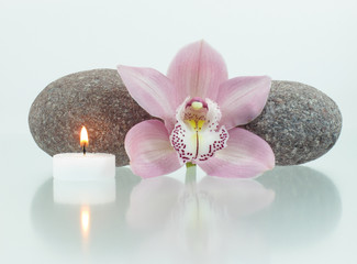 Fototapeta na wymiar Okrągłe kamienie, świec, orchidea