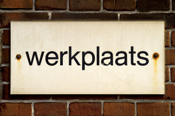 Sign board on brick wall