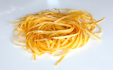 Fresh pasta shaped as tagliatelle drying on the table - 30382749