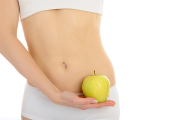 woman with beautiful body holding an apple near the slim waist.