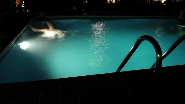 Swimming in a Pool at Night