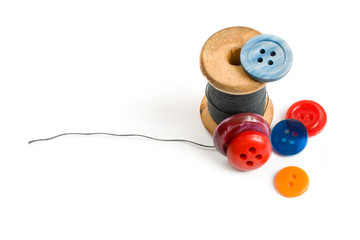 Thread bobbin and buttons isolated on white background