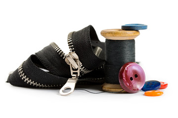 Thread bobbin, zipper and buttons isolated on white background